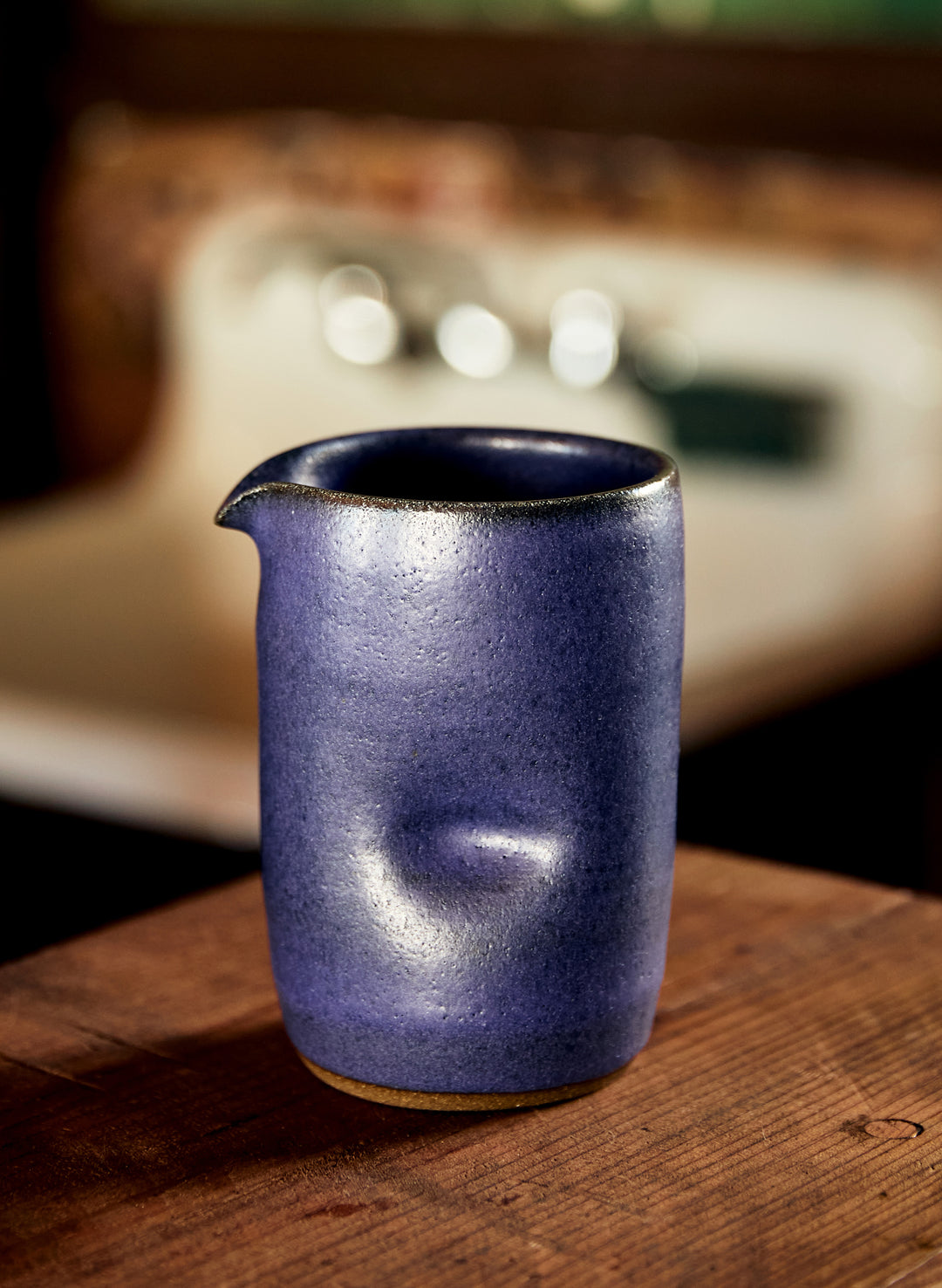 a blue ceramic cup on a wooden surface