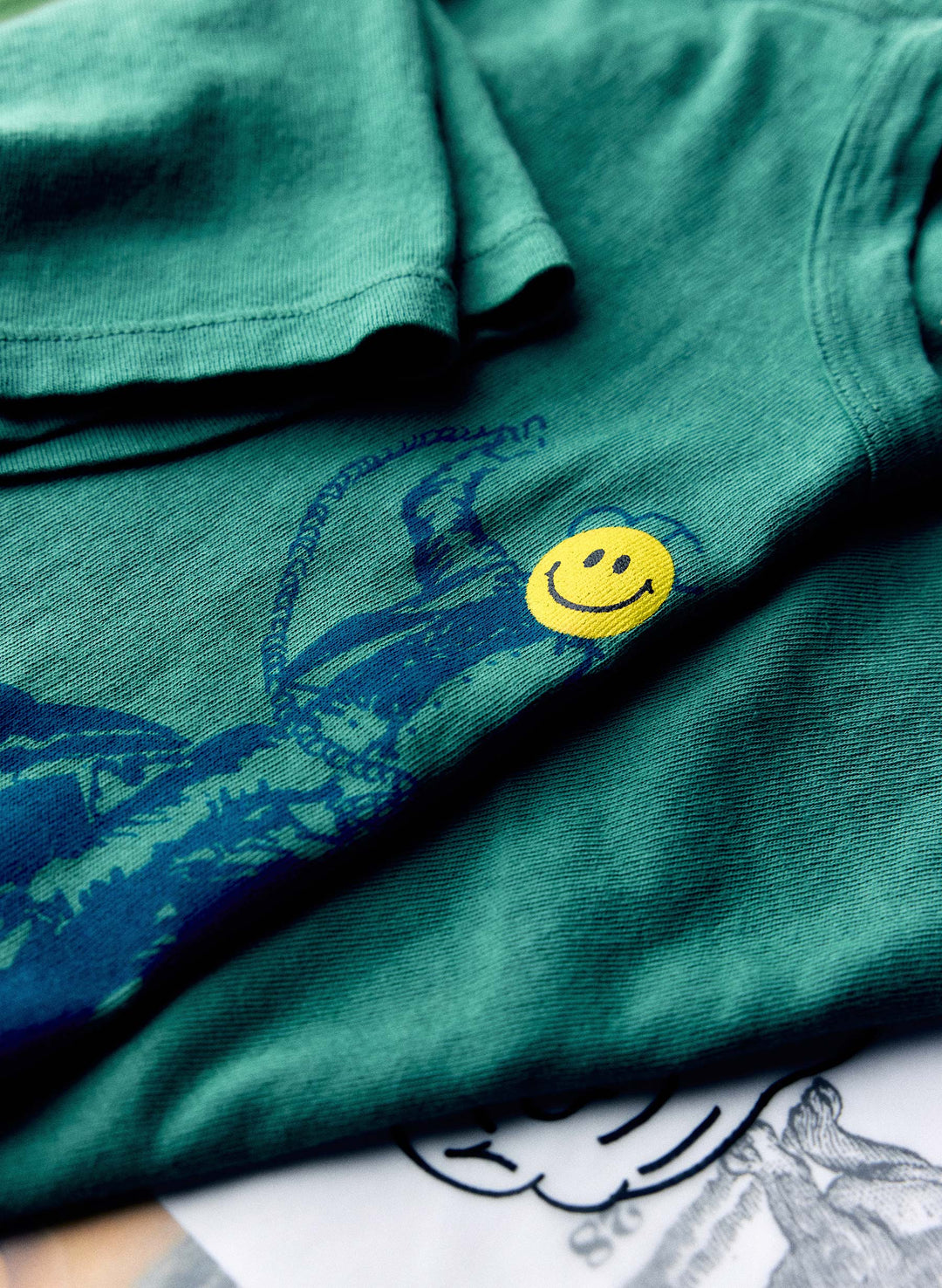 a green shirt with a smiley face on it