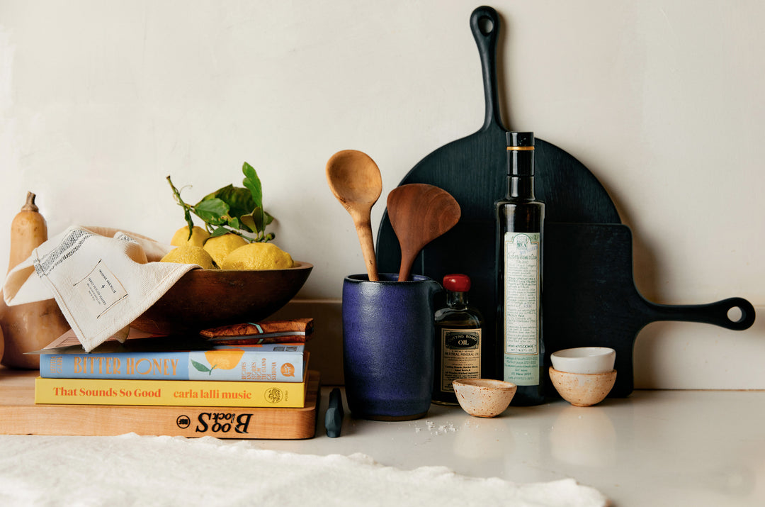 a kitchen utensils and a bowl of lemons on a counter