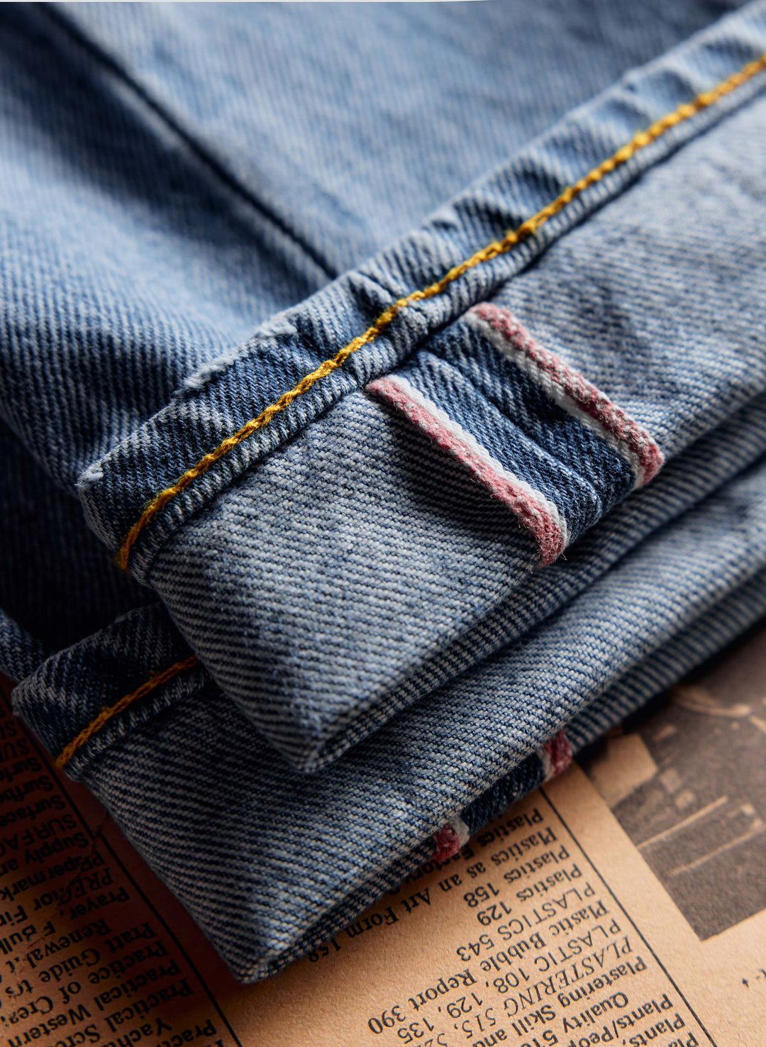 a pair of jeans folded on a newspaper