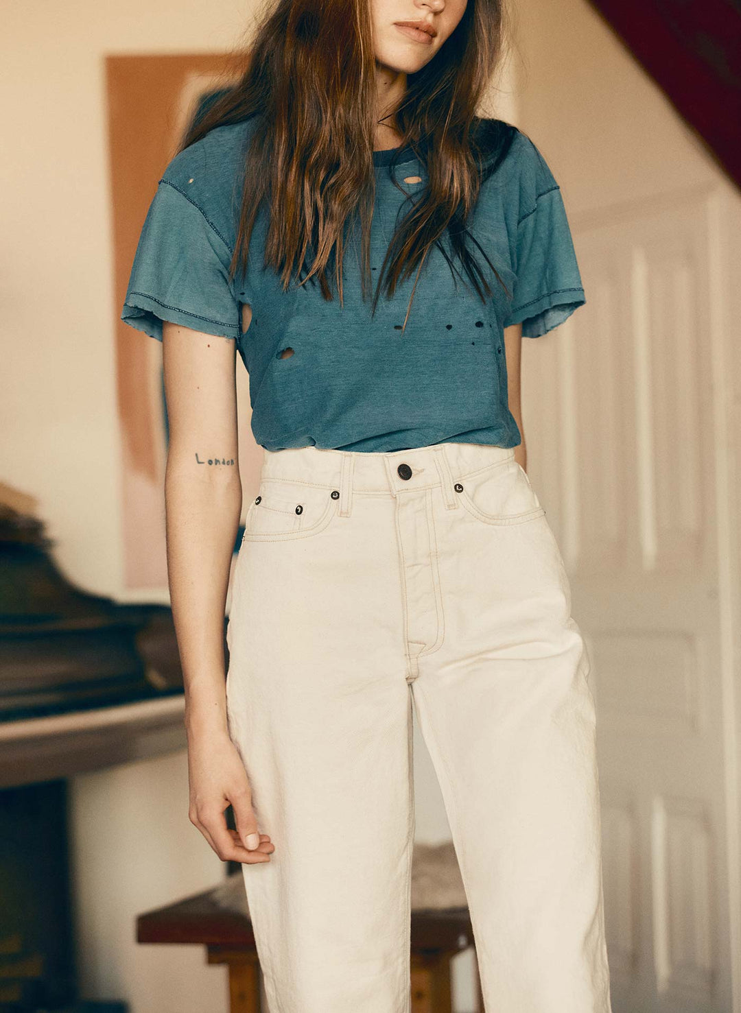 a woman wearing a blue shirt and white pants