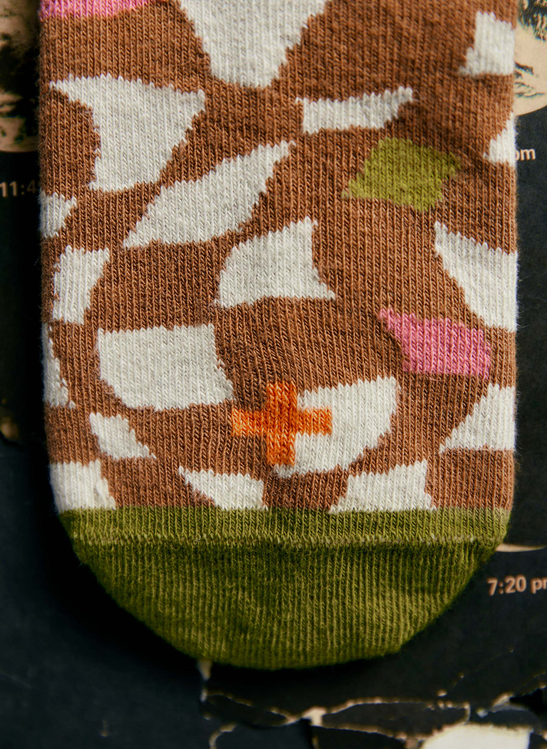 a brown and white sock with a cross on it