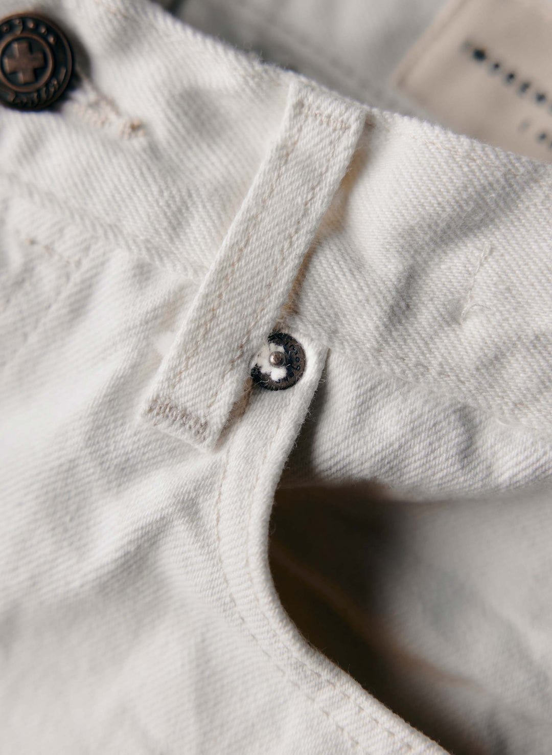 a close up of a button on a white pants
