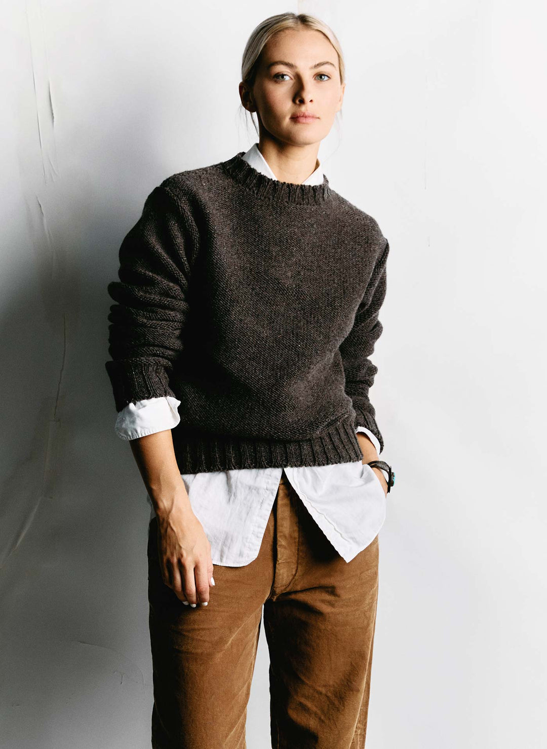 a woman in a sweater and brown pants