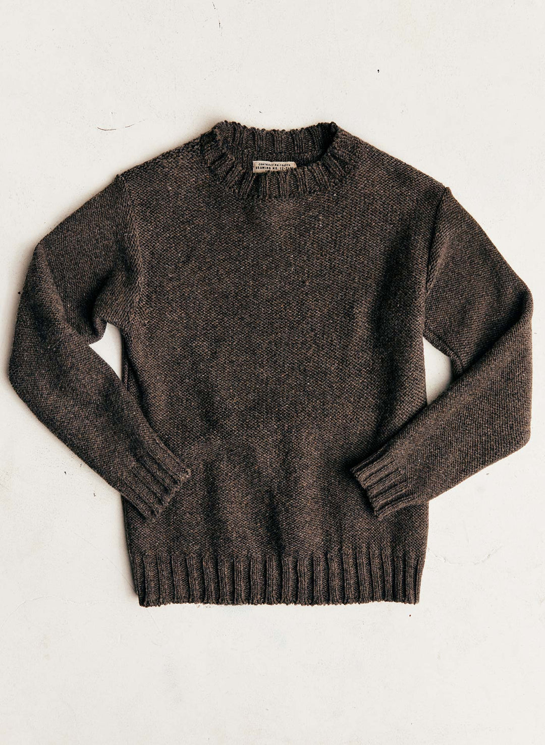 a brown sweater on a white surface