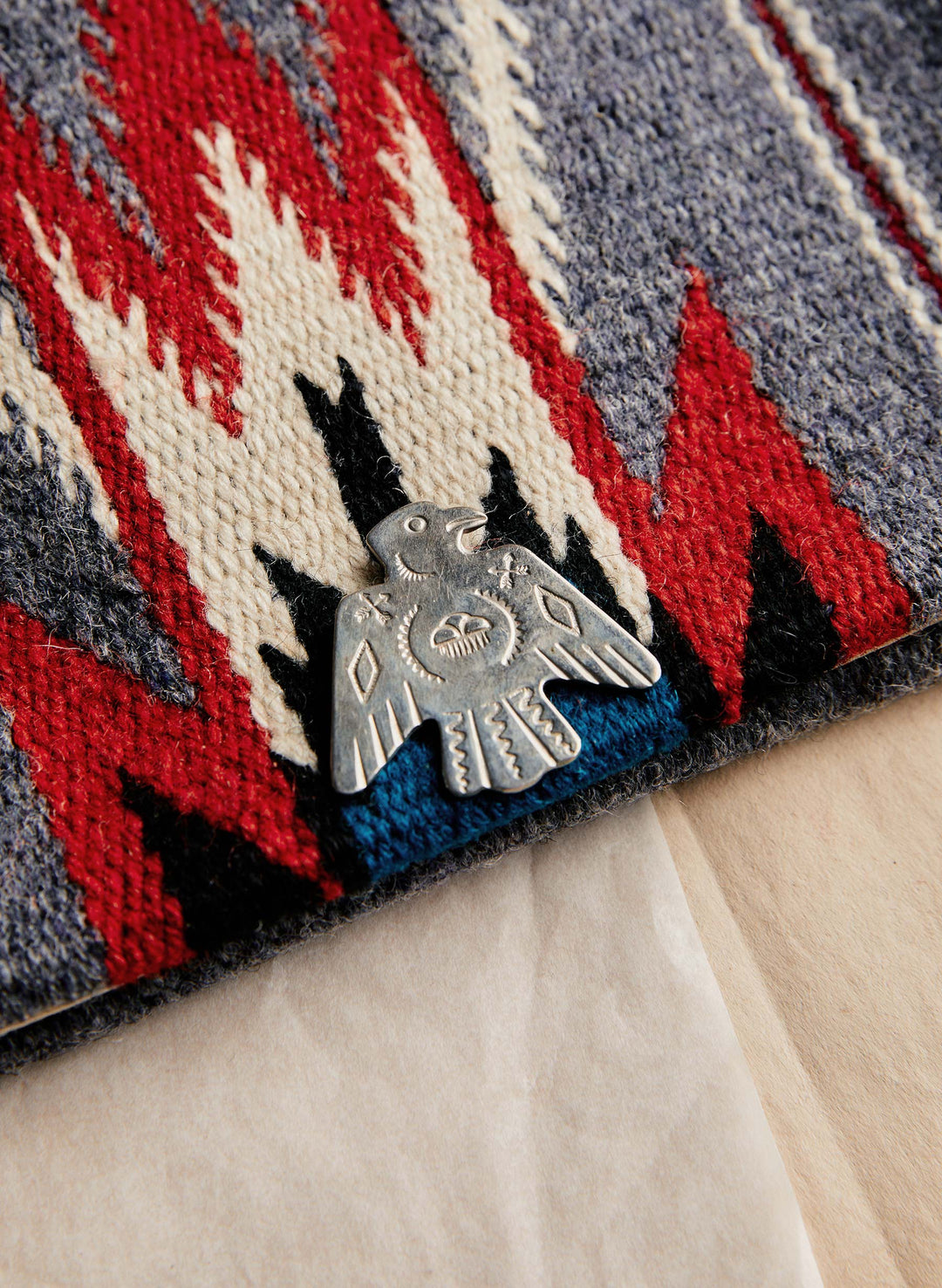 a metal bird pin on a fabric surface