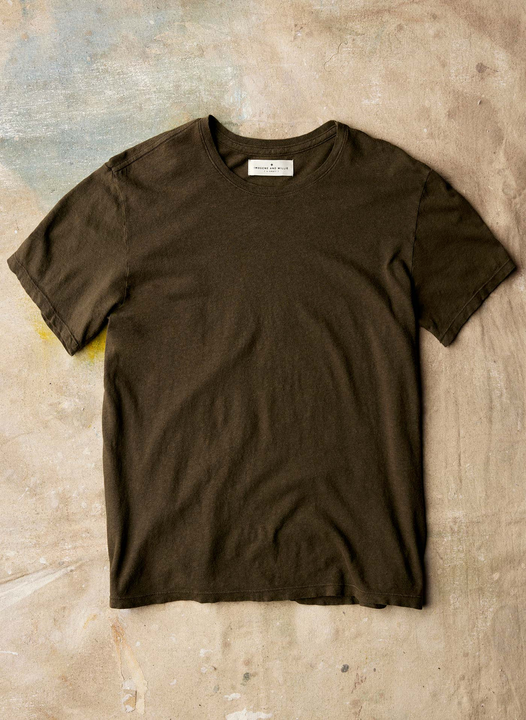 a brown t-shirt on a concrete surface