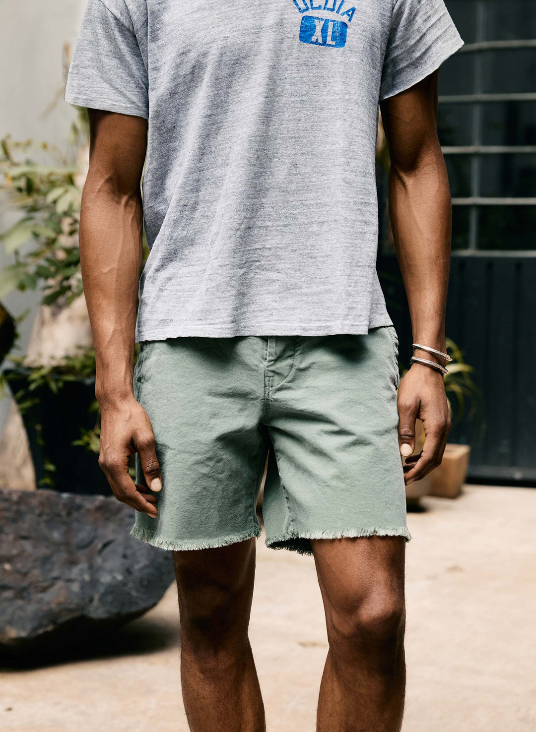 a man wearing shorts and a grey shirt