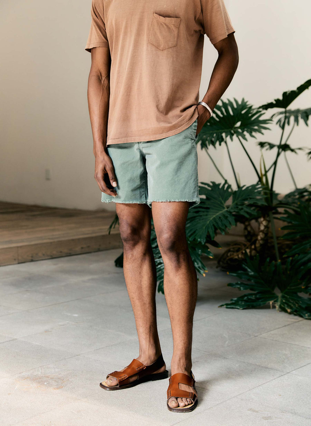 a man wearing shorts and a brown shirt