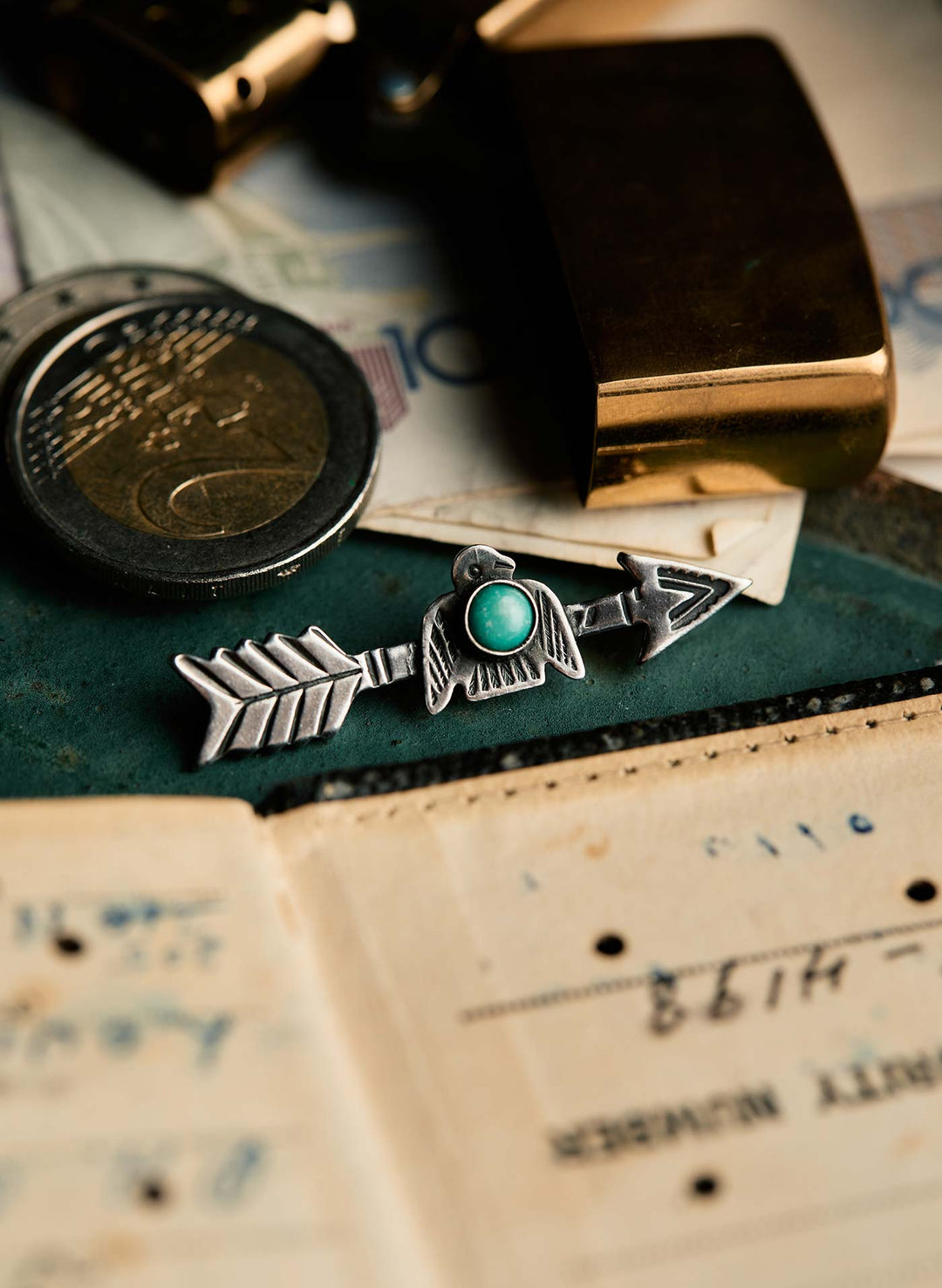 a silver arrow and coins on a table