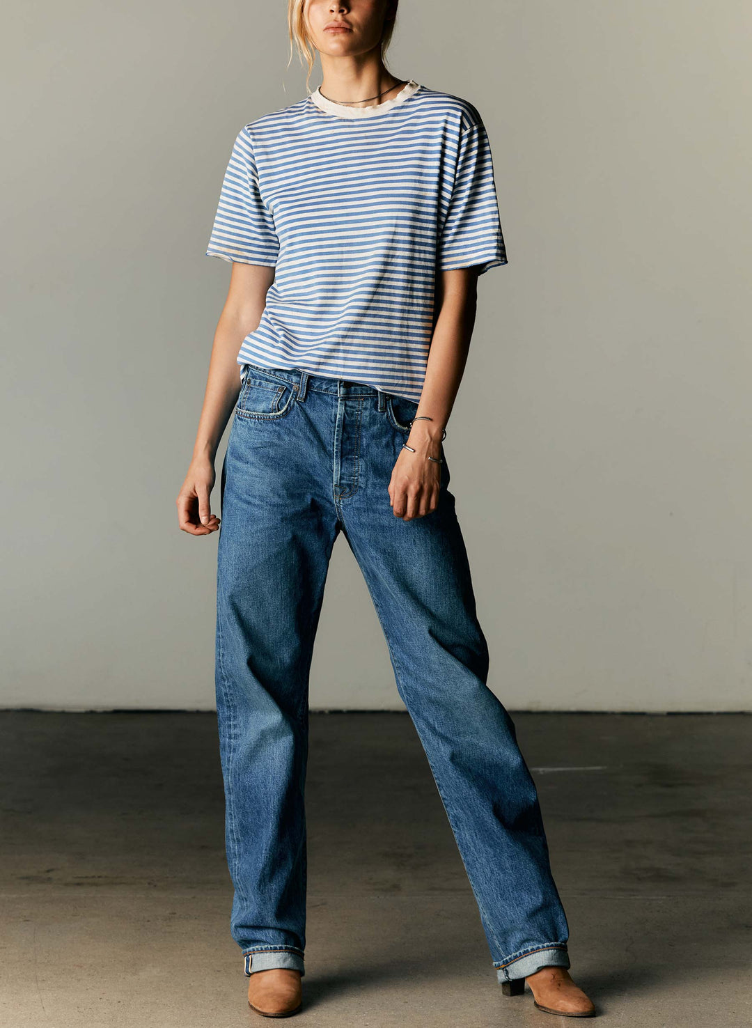 a woman in a striped shirt and jeans