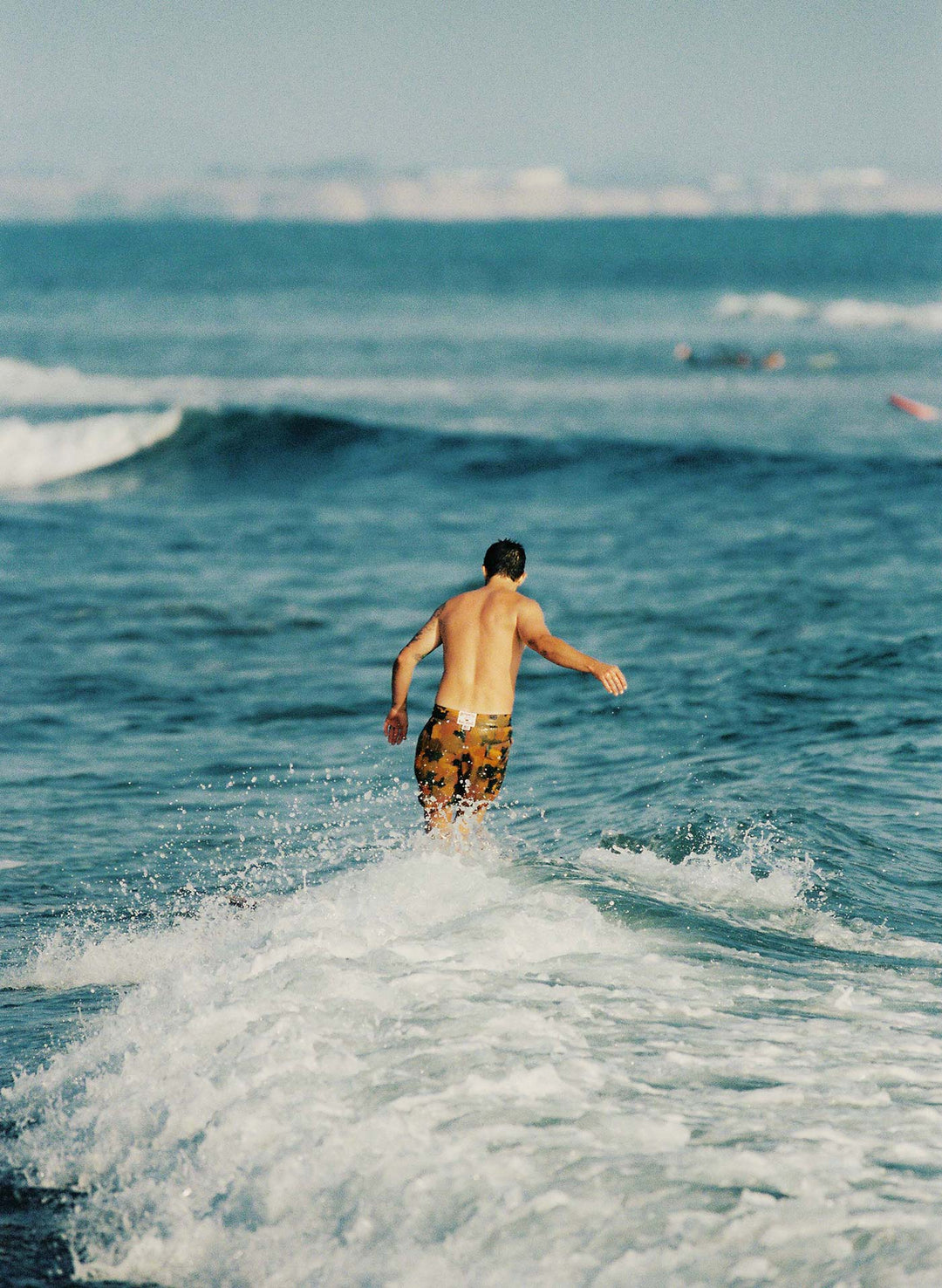 a man in shorts surfing in the ocean