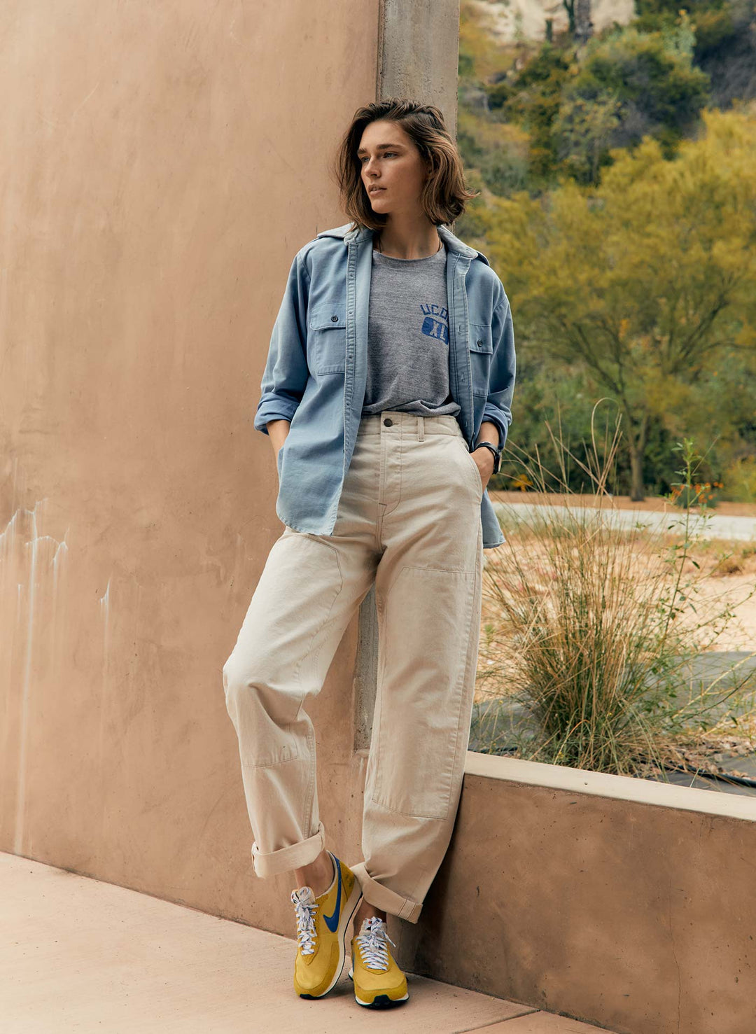 a woman standing against a wall