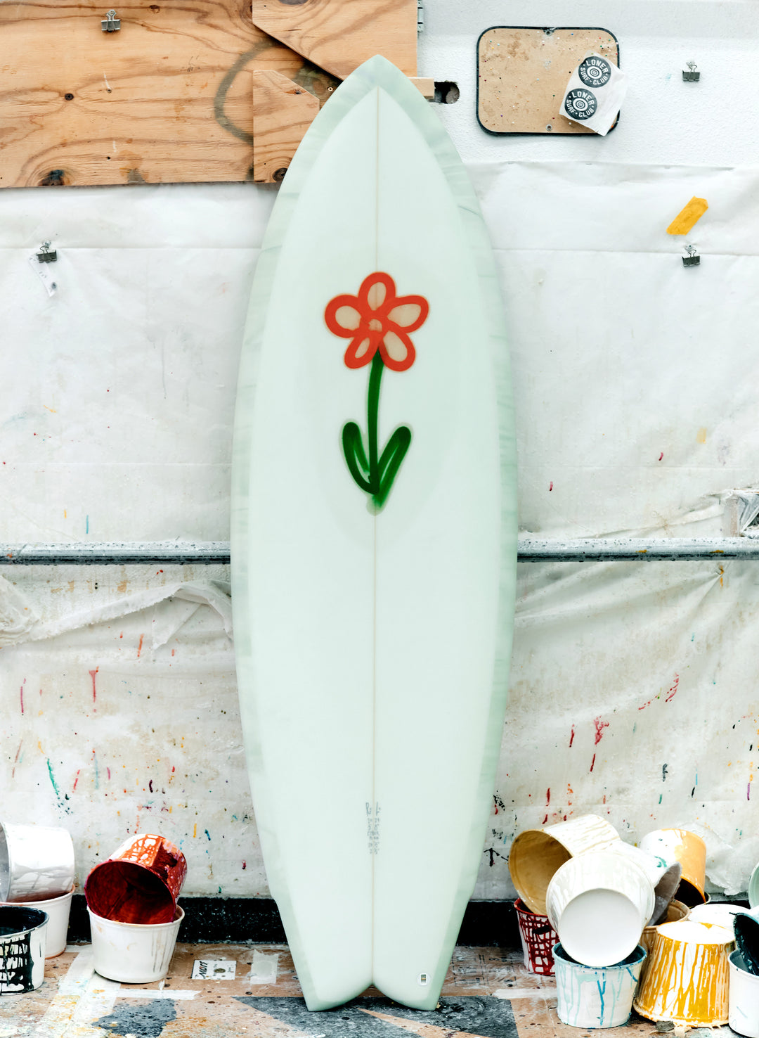 a surfboard with a flower drawn on it