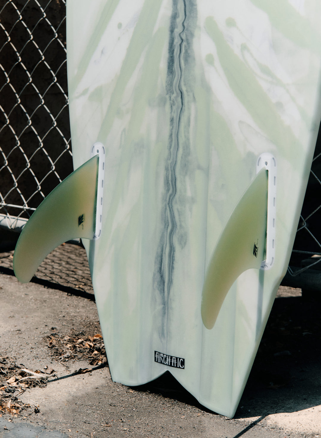 a surfboard leaning against a fence