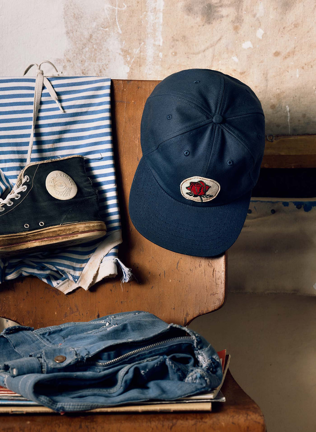 a blue hat and black shoe on a wooden chair