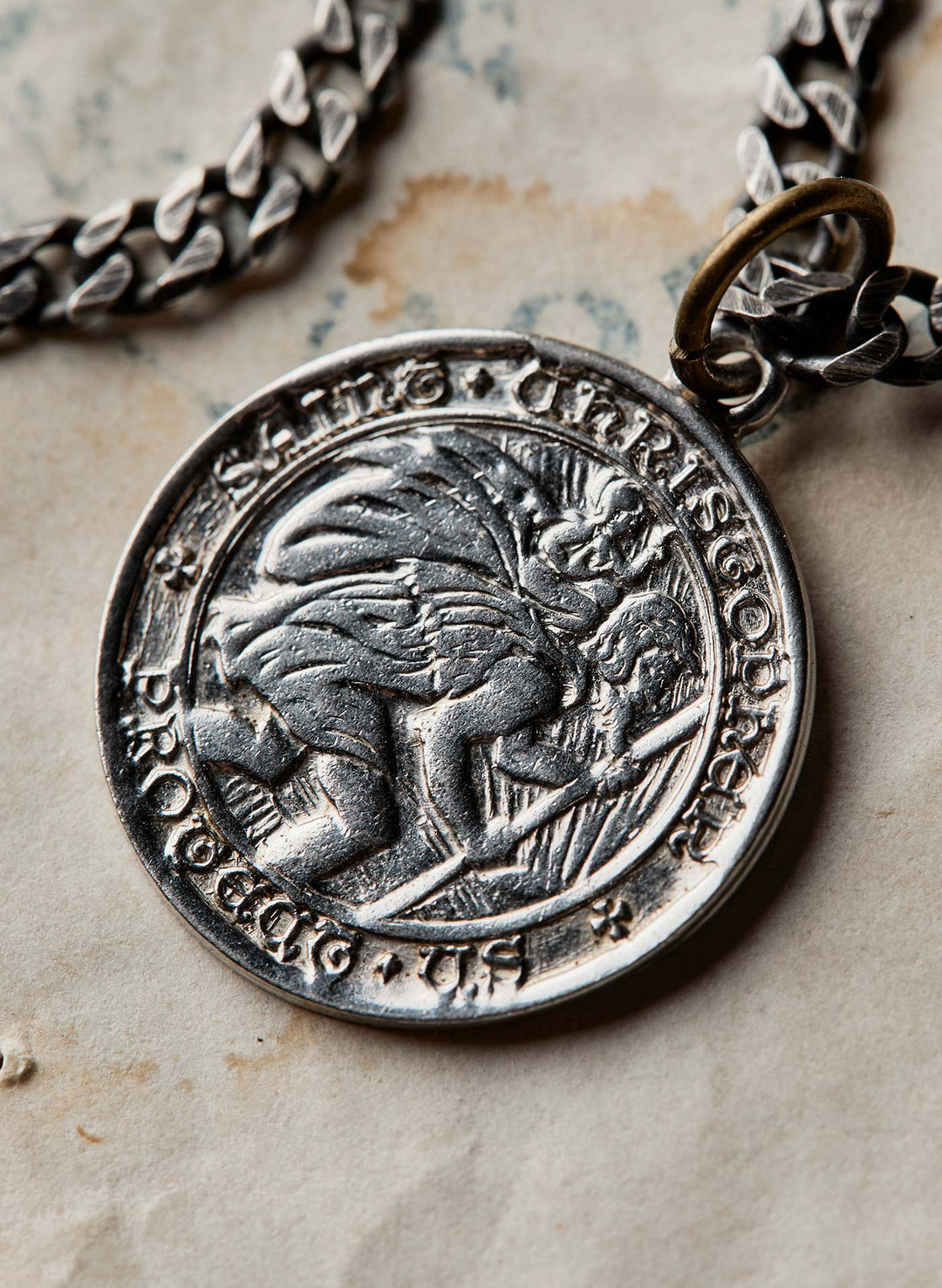 a silver medallion with a chain