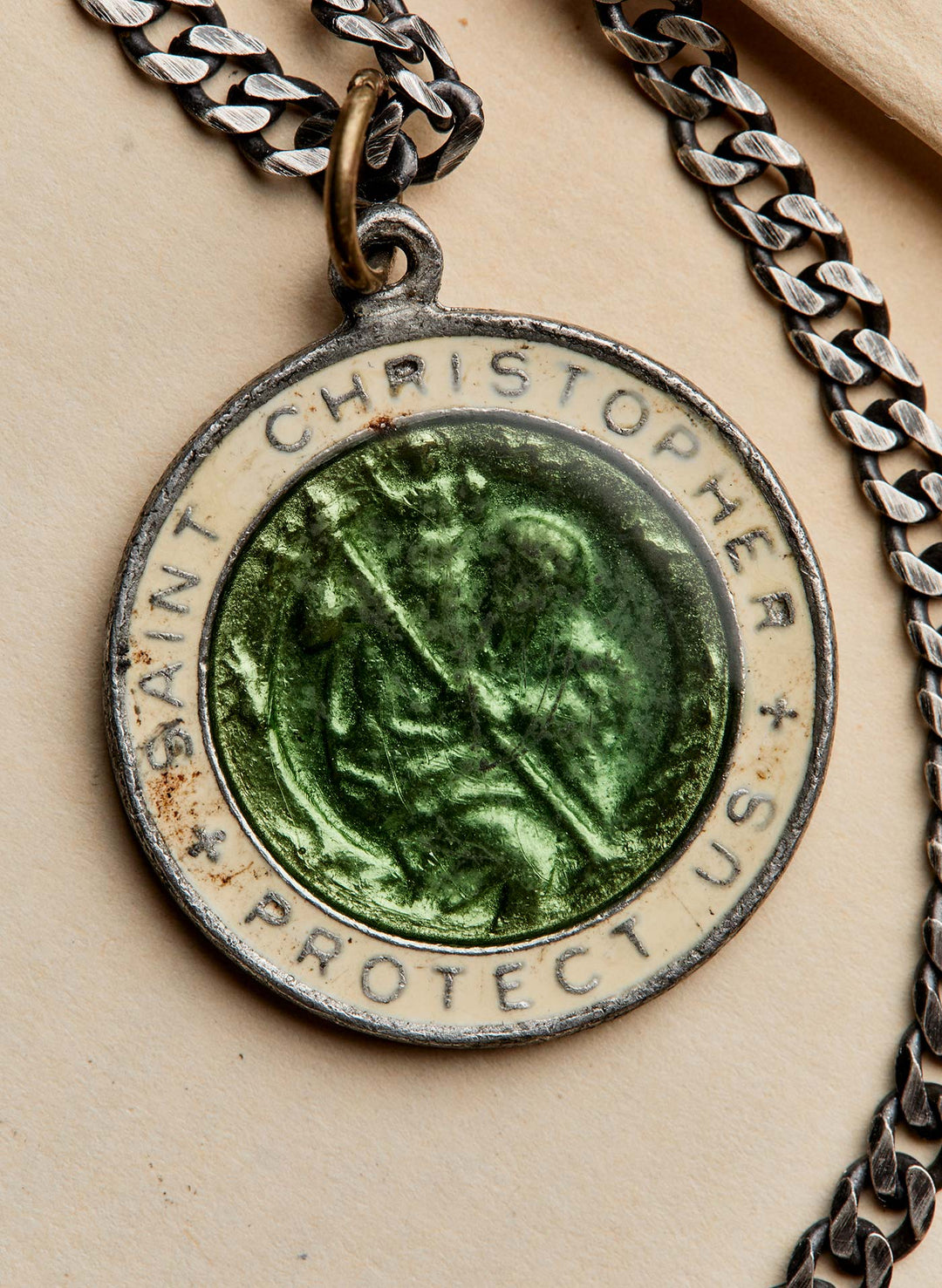 a green medallion with a chain