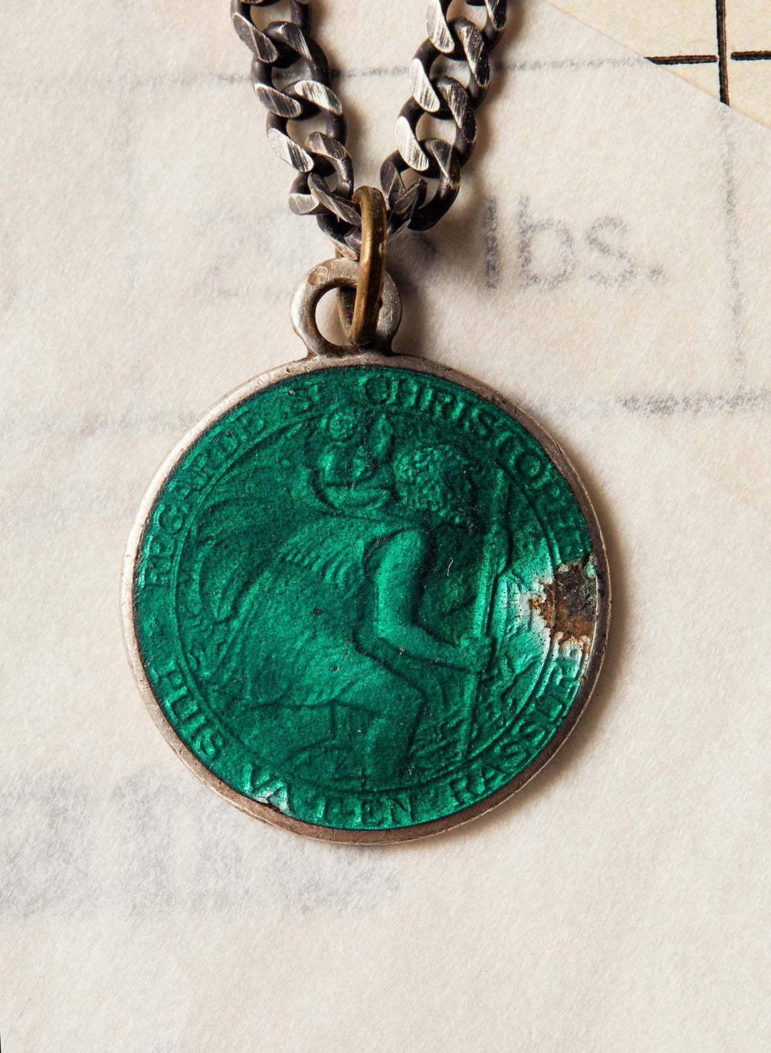 a green coin with a silver chain