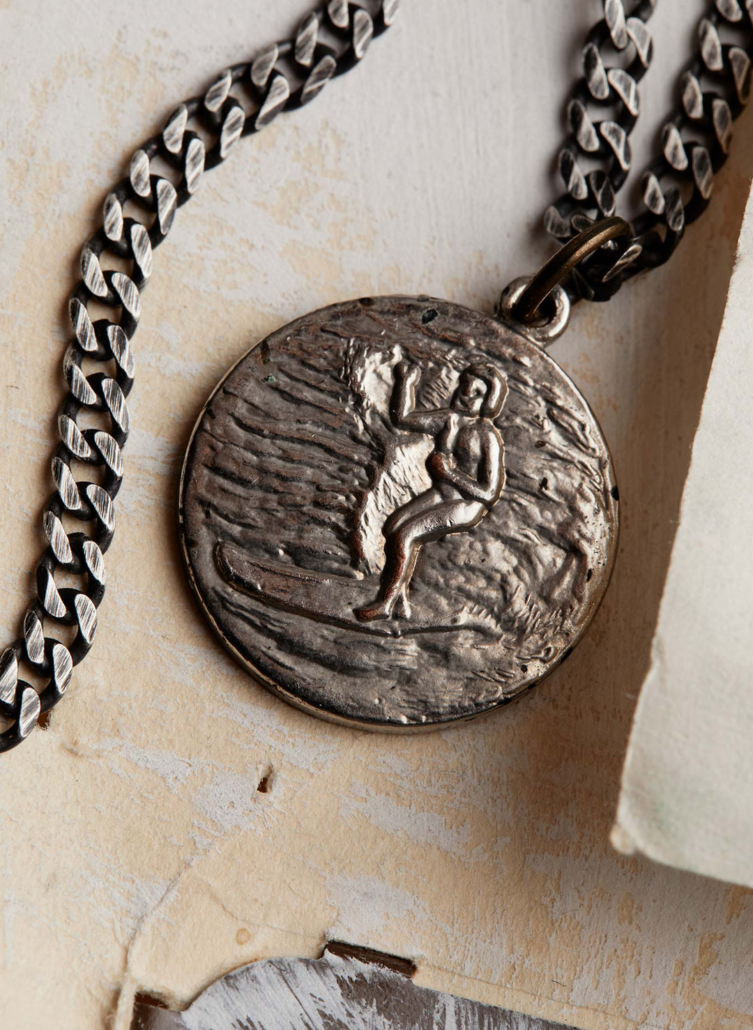 a silver medallion with a chain