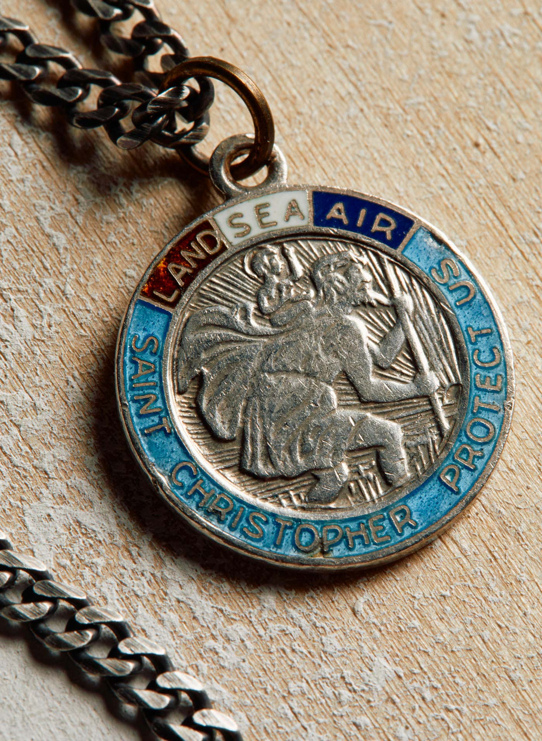 a silver medallion with a blue and white text on it