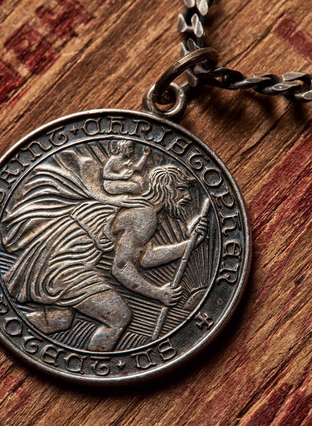 a silver coin with a chain on a wood surface