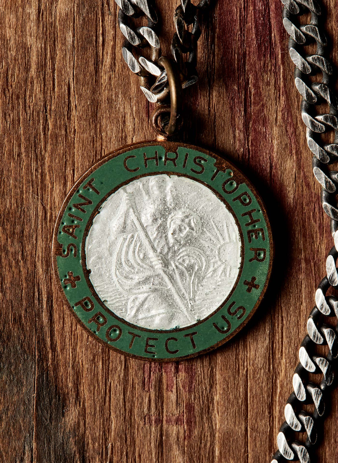 a medallion with a chain on a wood surface