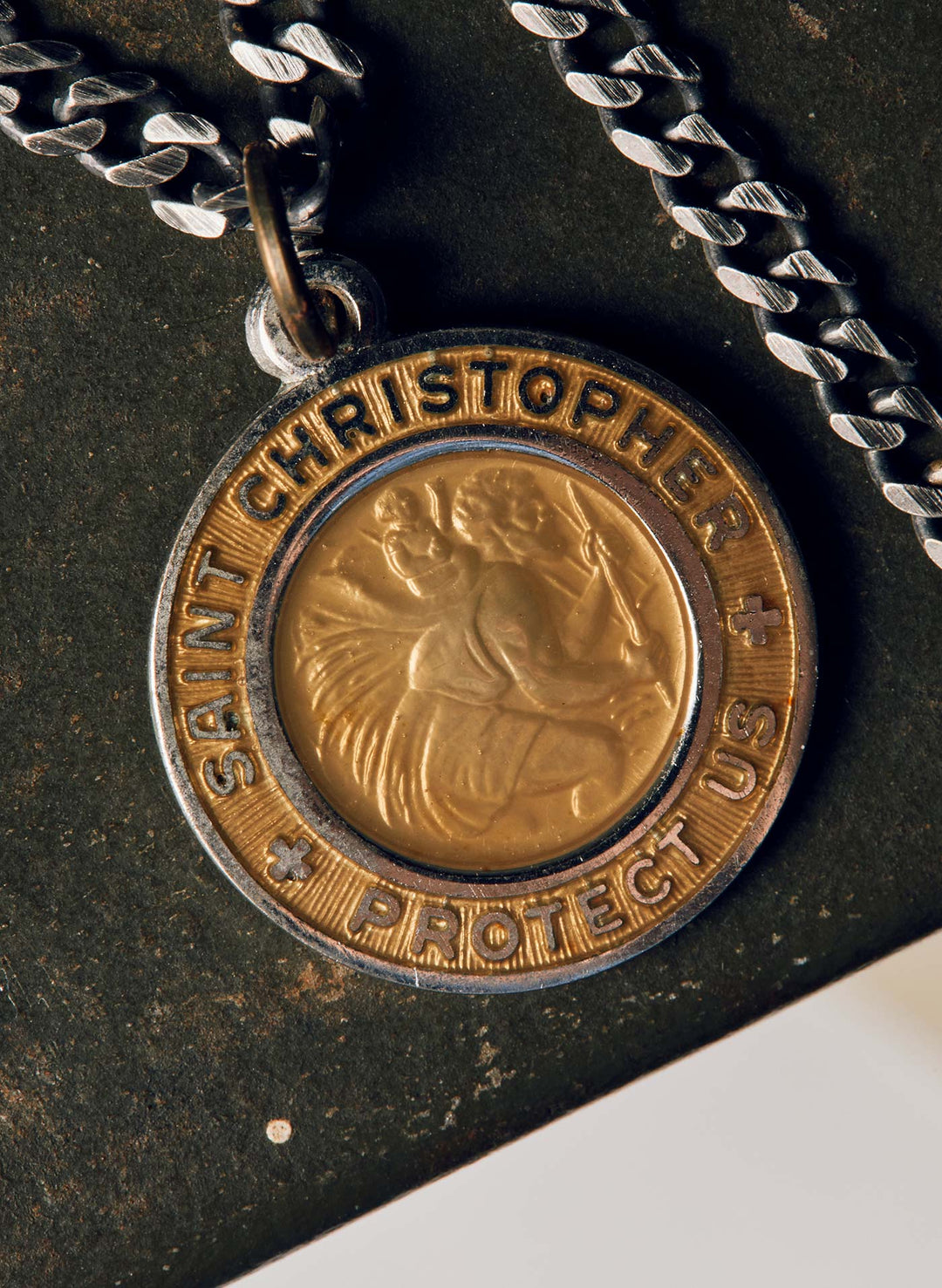 a gold and silver medallion with a chain