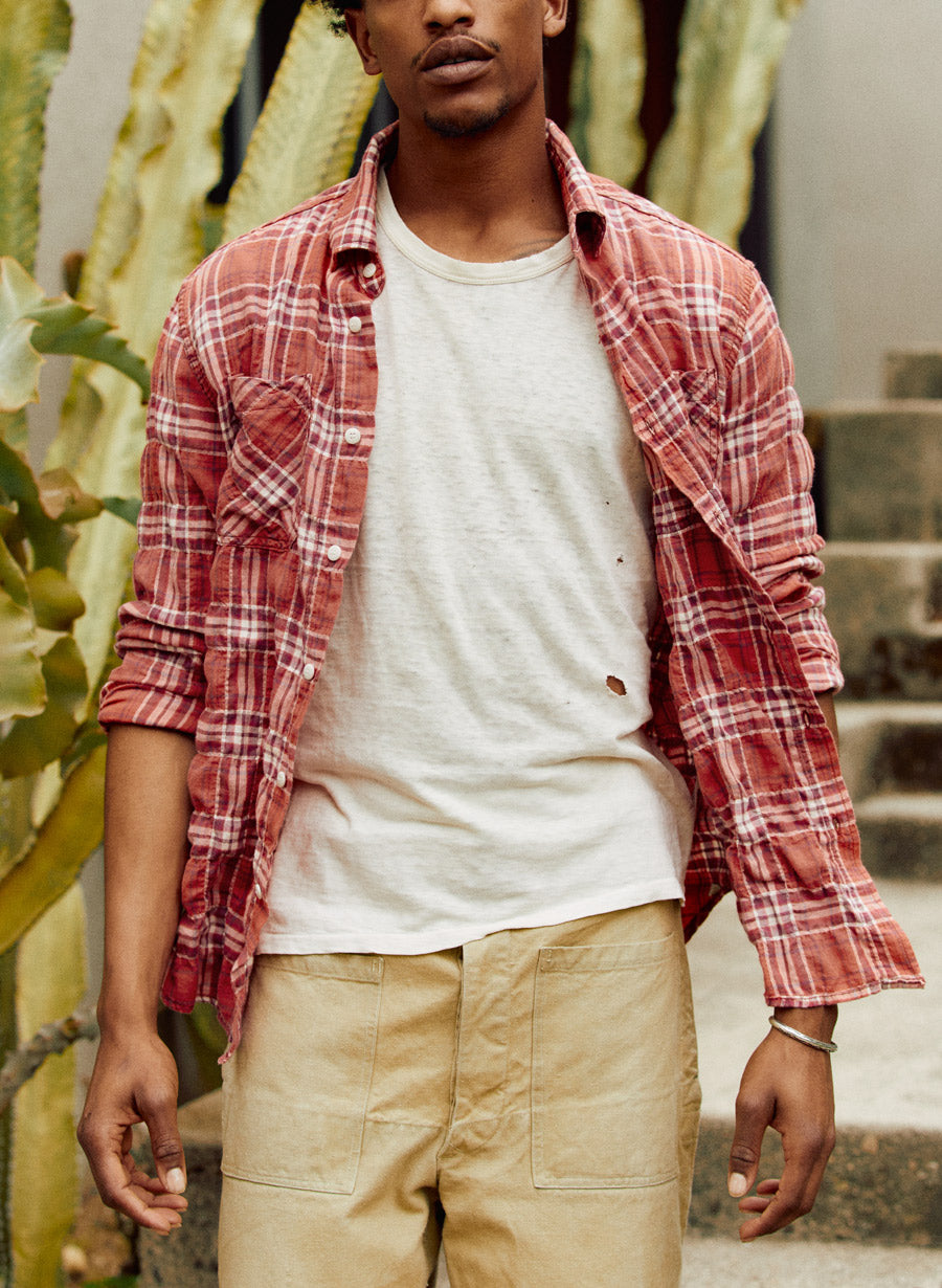 a man wearing a red flannel shirt and tan shorts