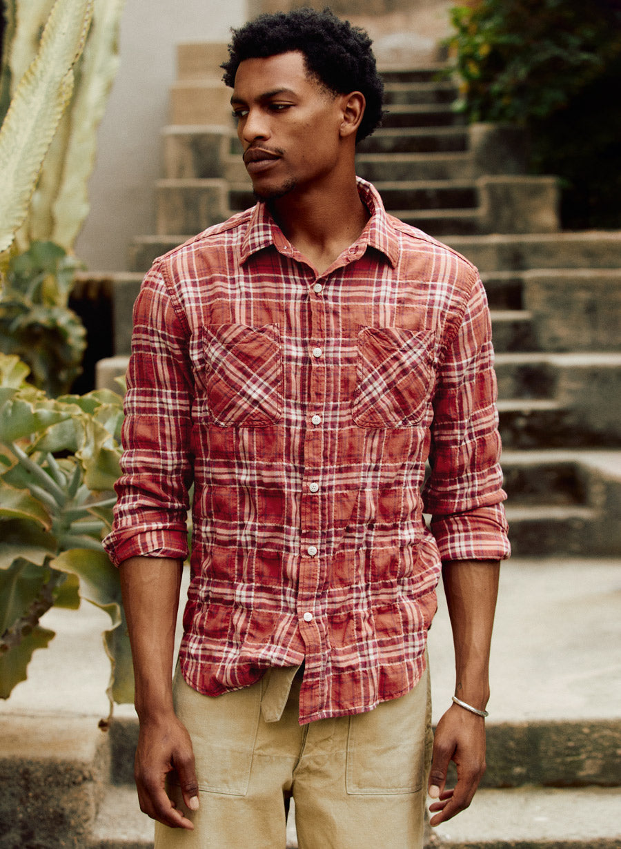 a man standing outside with a red plaid shirt