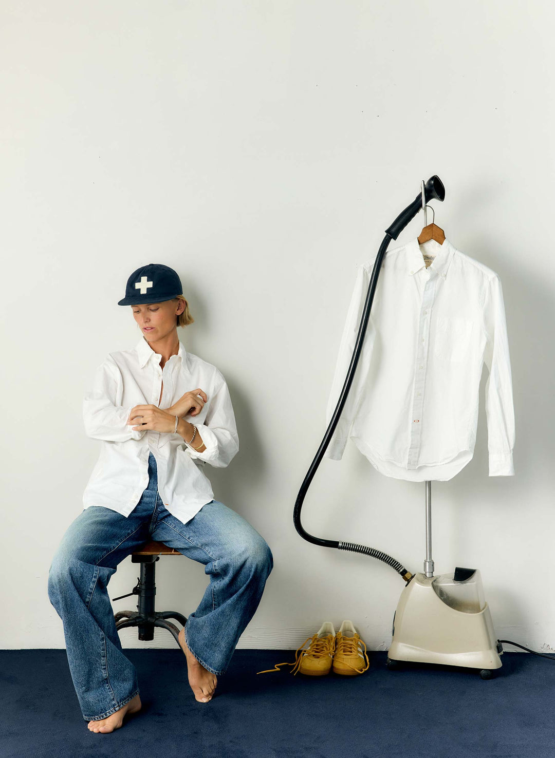 a woman sitting on a chair next to a ironing board