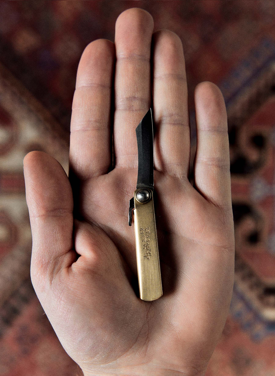a hand holding a small knife