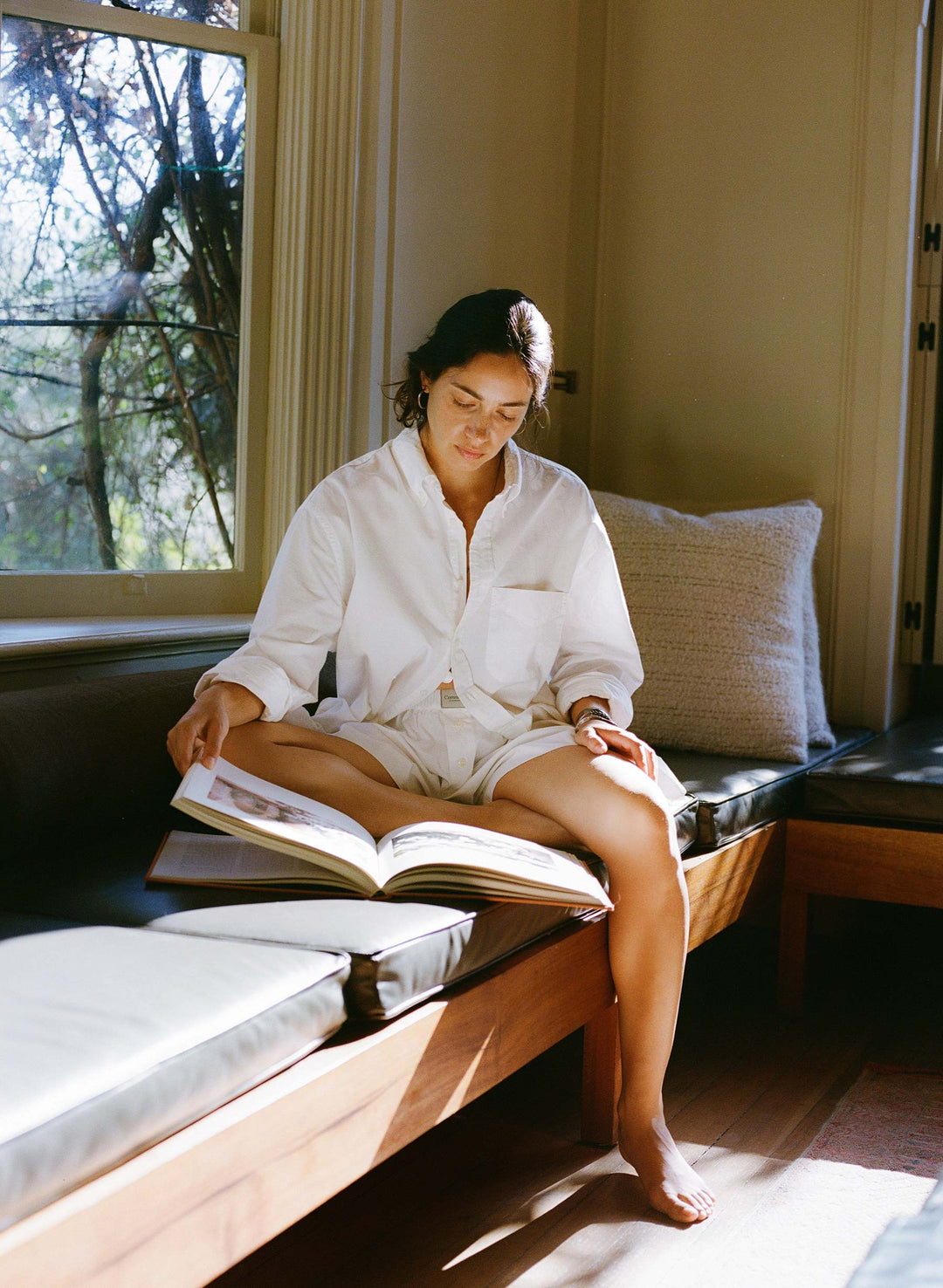 a woman sitting on a bench reading a book