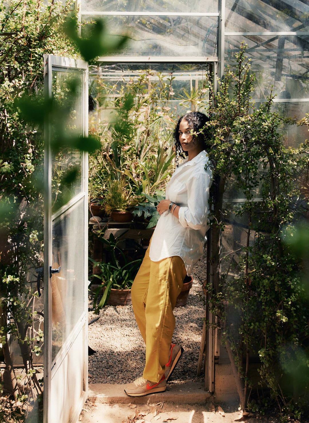 a woman standing in a greenhouse