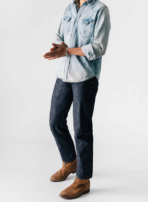 a man in a denim shirt and jeans