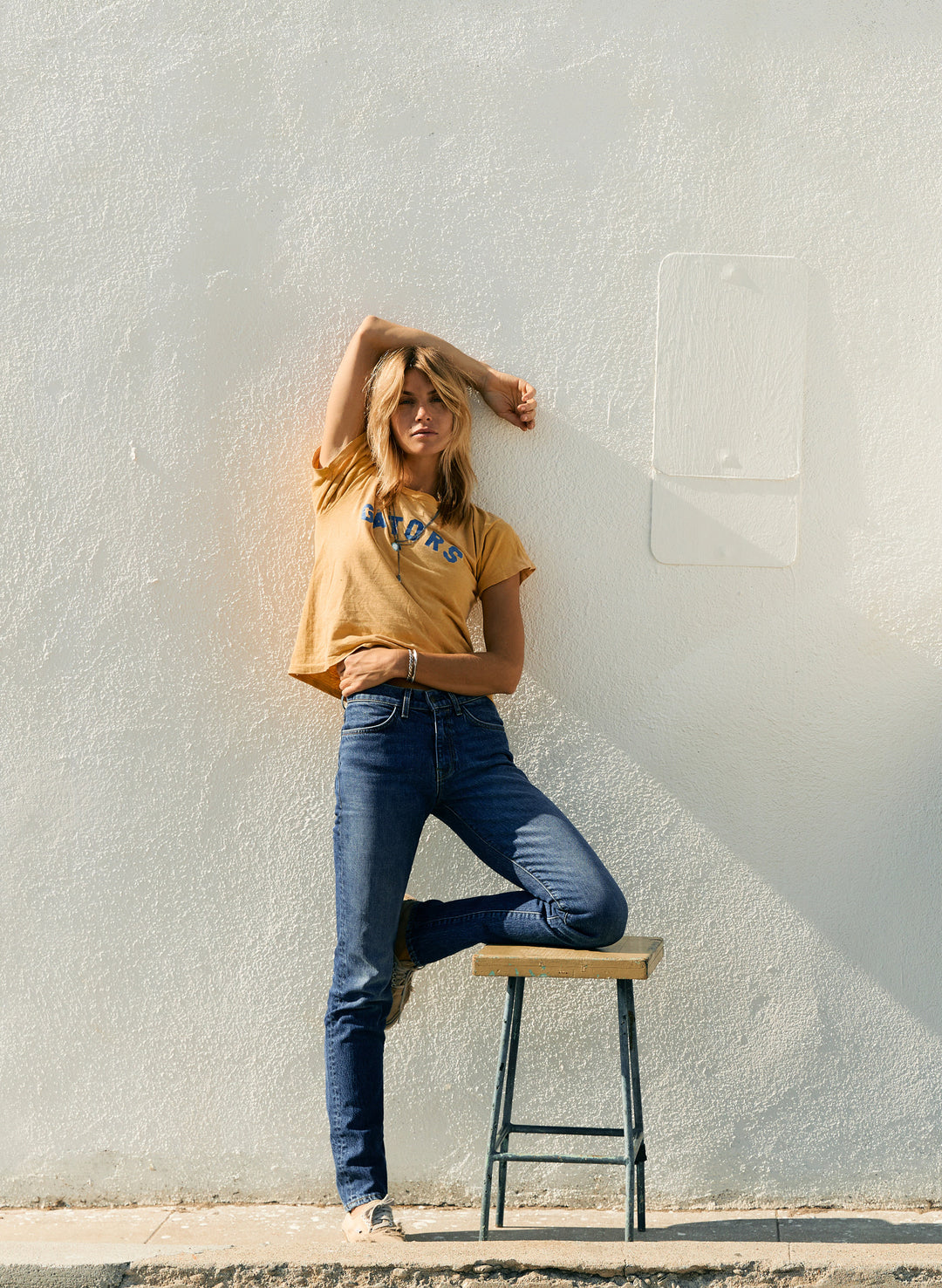 a woman leaning against a wall