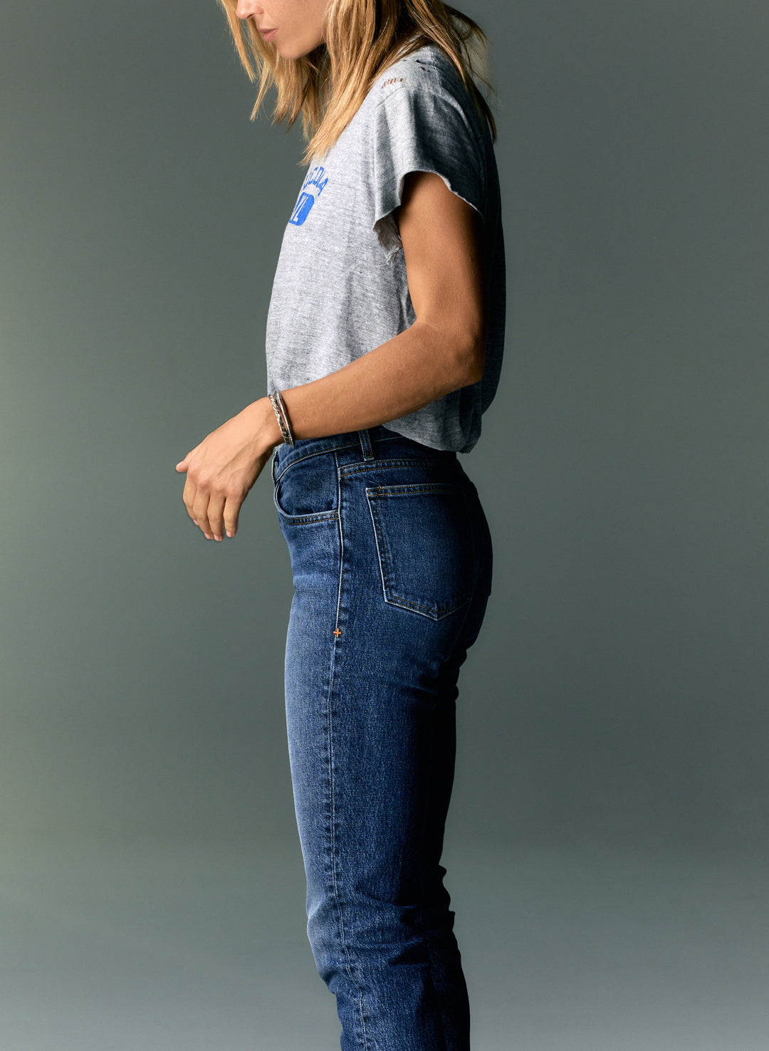 a woman standing in front of a grey wall