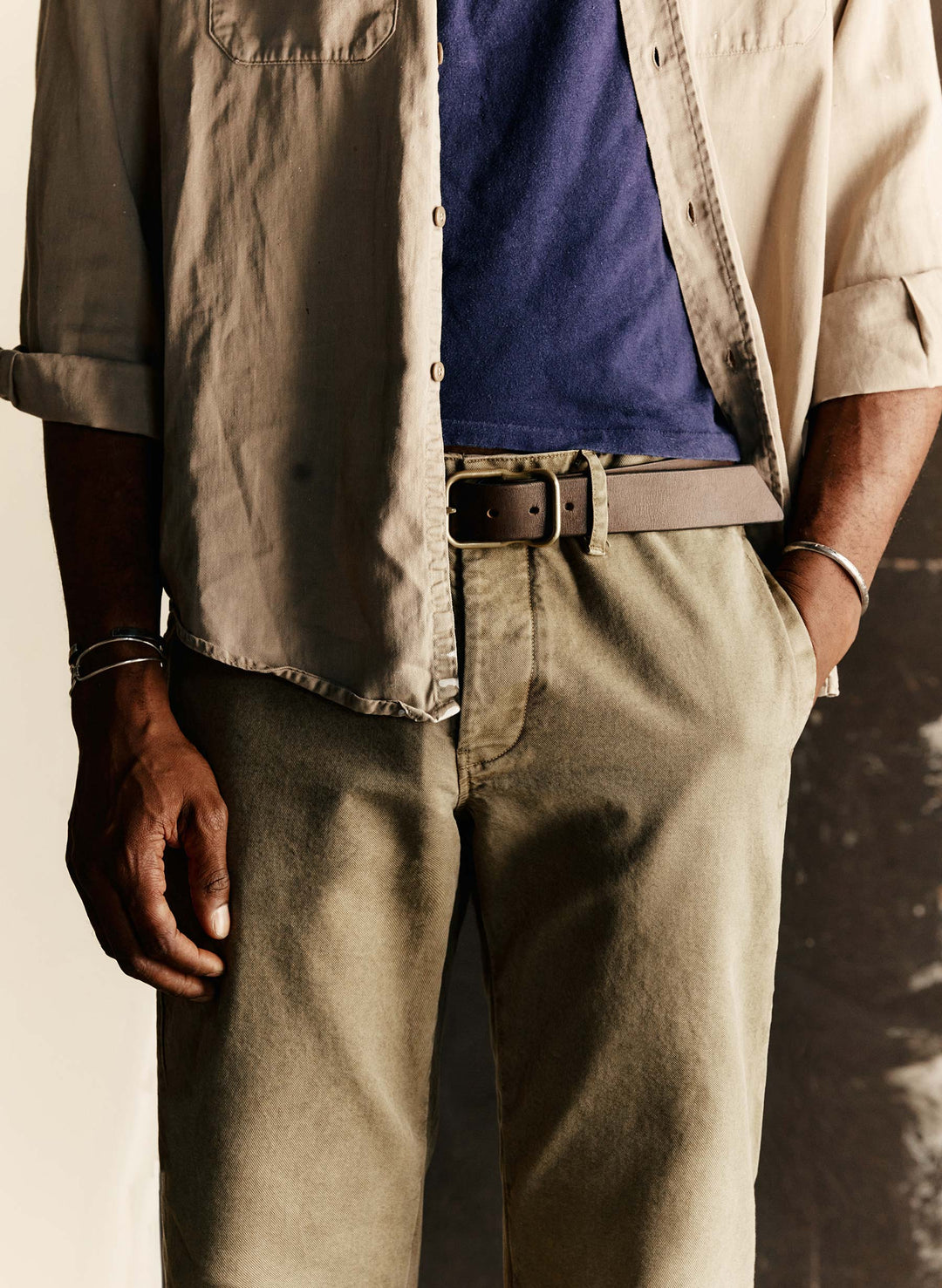 a man wearing a blue shirt and brown pants