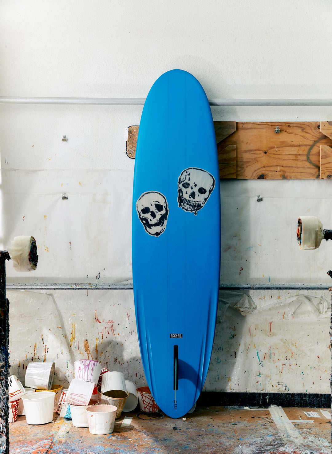 a blue surfboard with skulls stickers on it