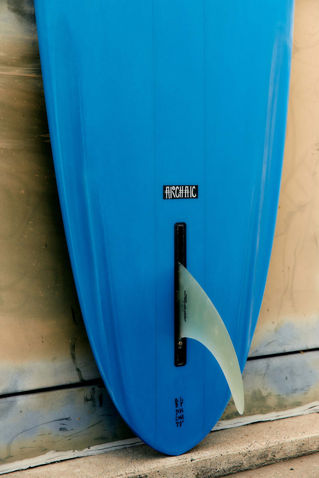 a blue surfboard with a fin attached to a wall