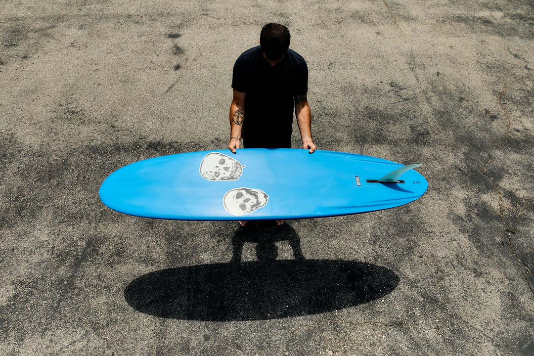 a man holding a blue surfboard