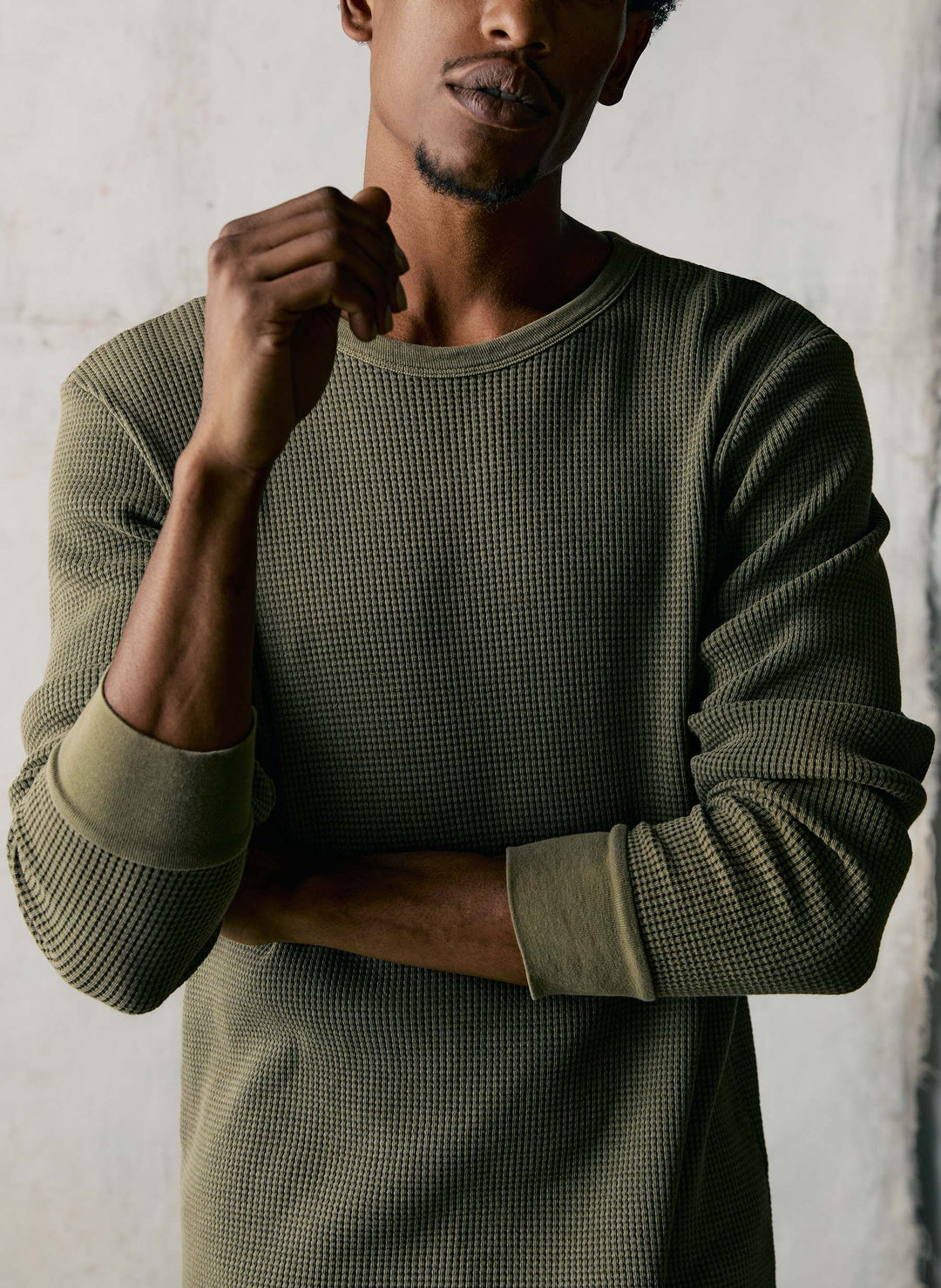 a man with a beard wearing a green sweater