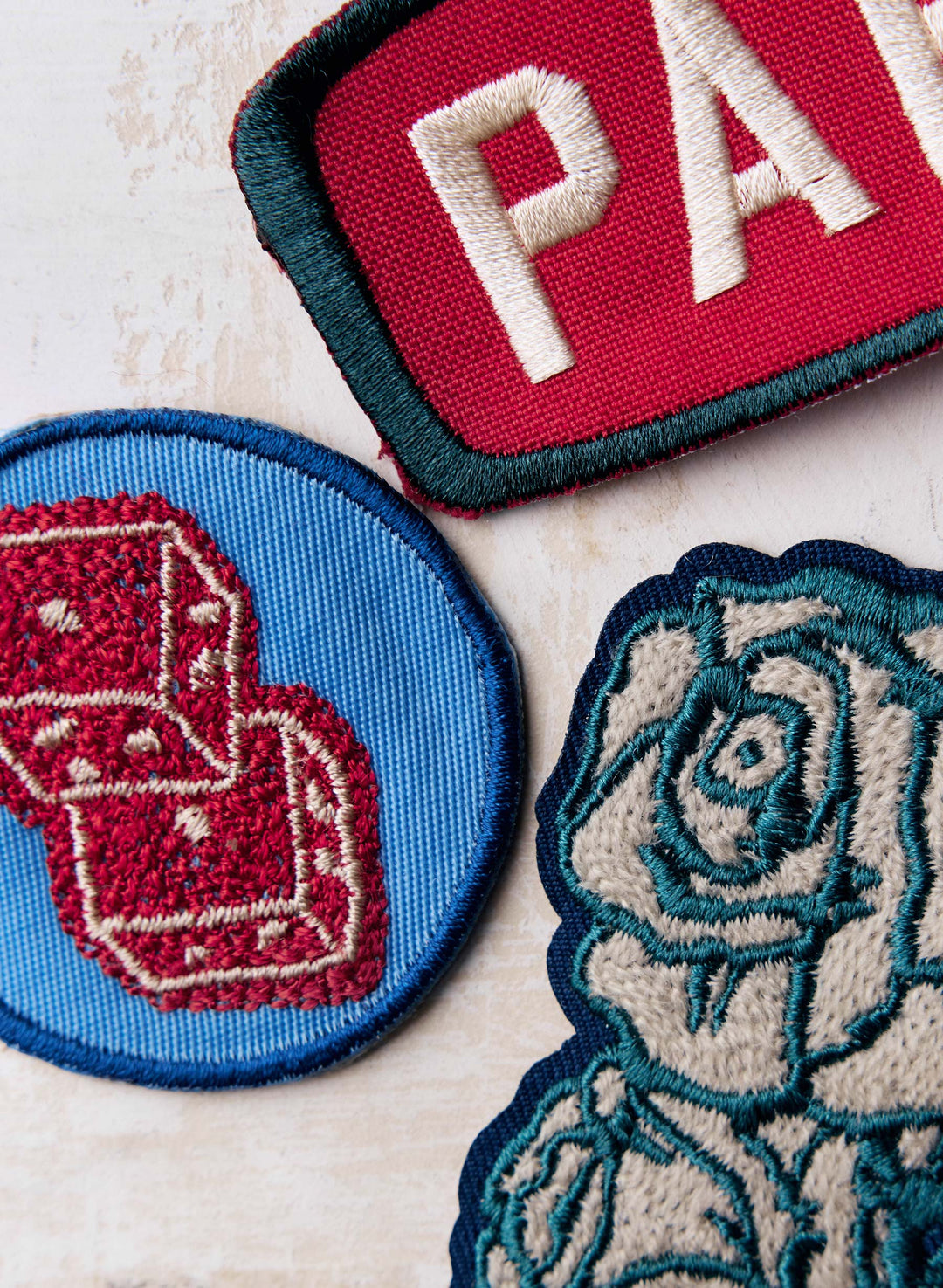 a group of patches with a red dice and a rose