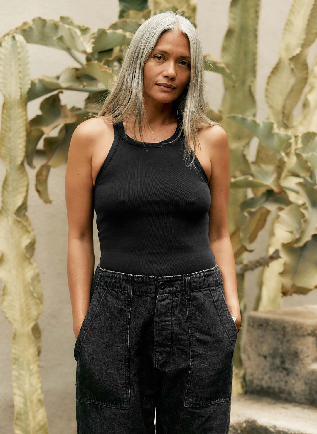 a woman standing in front of a plant