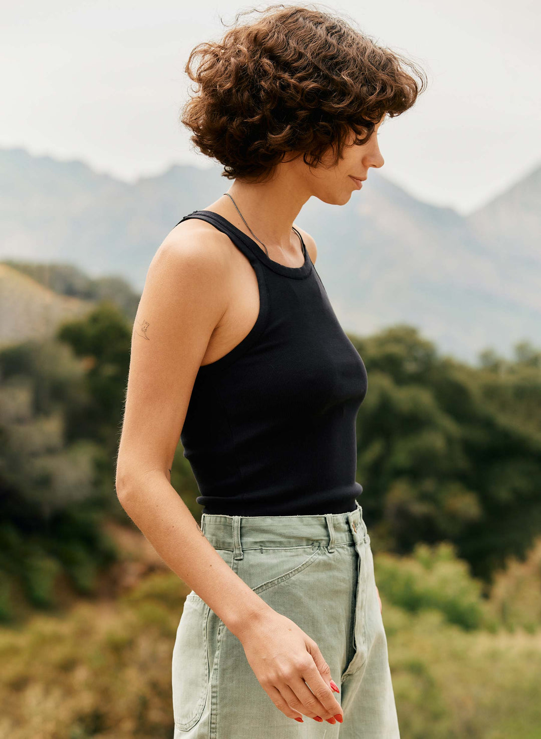 a woman standing outside with mountains in the background