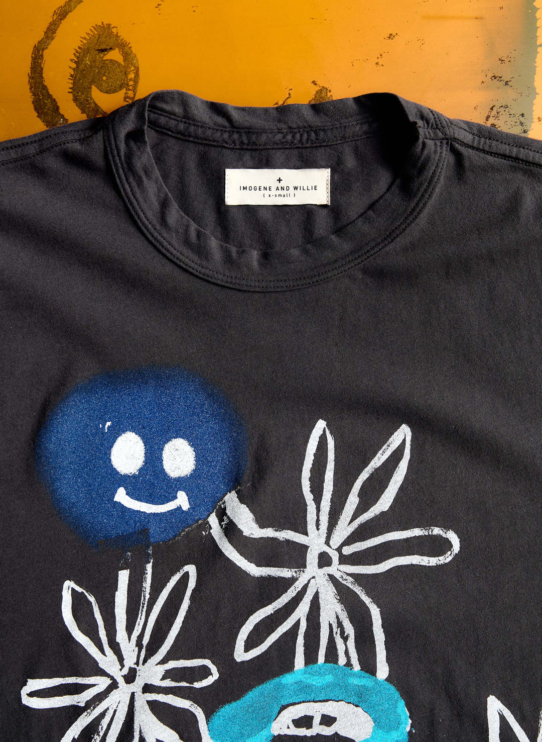 a black shirt with a blue flower and a white flower on it