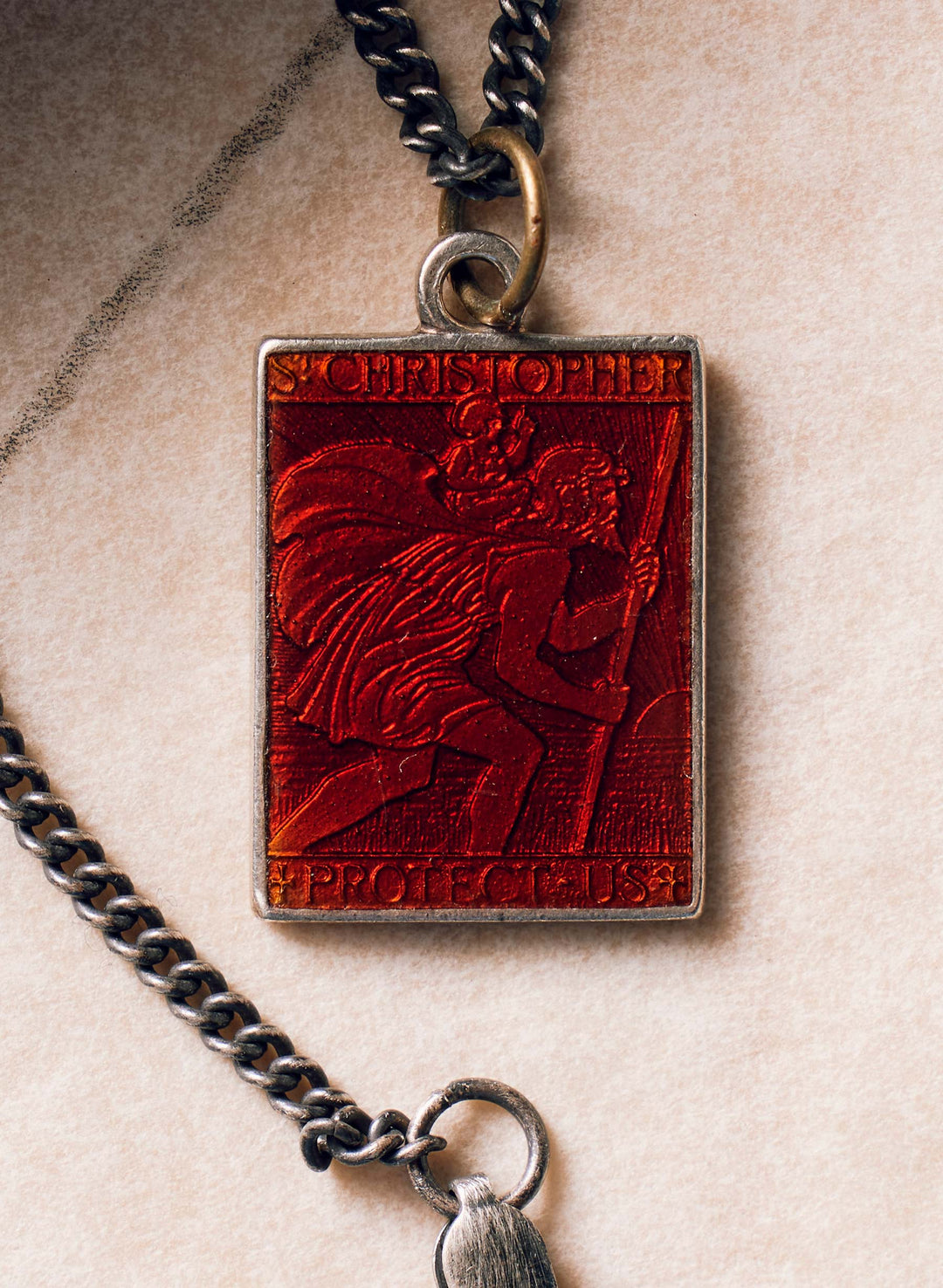 a red rectangular pendant with a silver chain