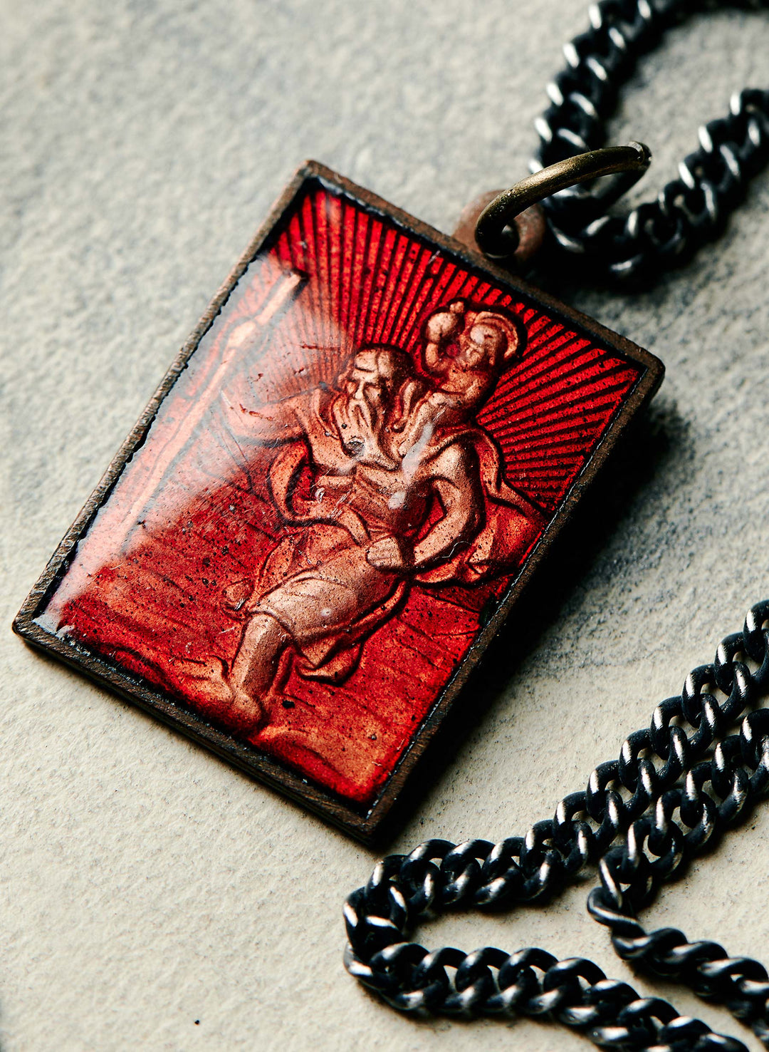 a red and silver necklace with a red rectangular object