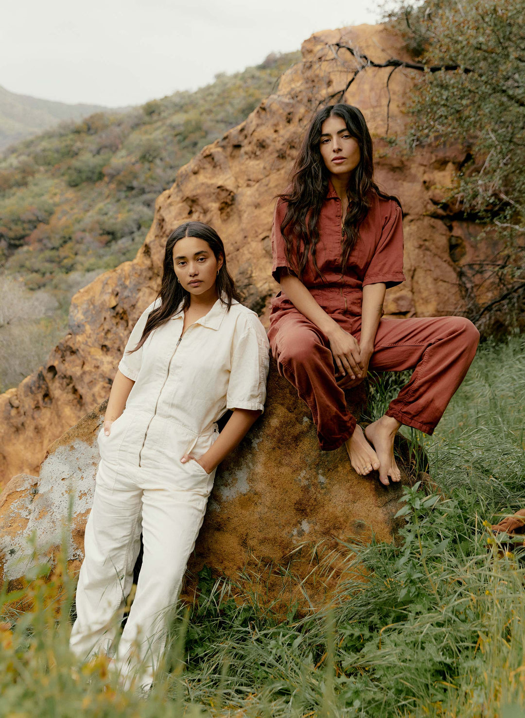 two women sitting on a rock