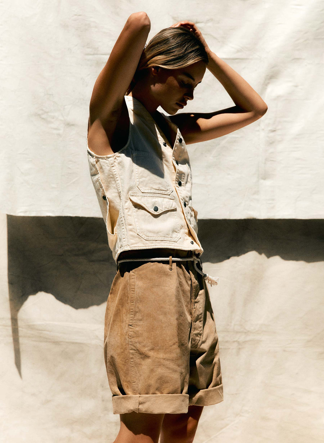 a woman in a vest and brown pants